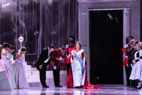 Degli attori sono in scena sul palco durante l'opera "Elisabetta Regina d'Inghilterra". La regina sta entrando in sala e la gente si inchina a lei