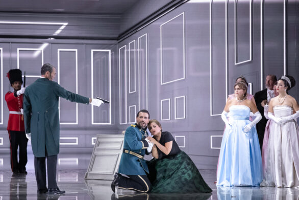 Degli attori sono in scena sul palco durante l'opera "Elisabetta Regina d'Inghilterra". Un uomo sta puntando la pistola su due personaggi seduti sul pavimento del palco