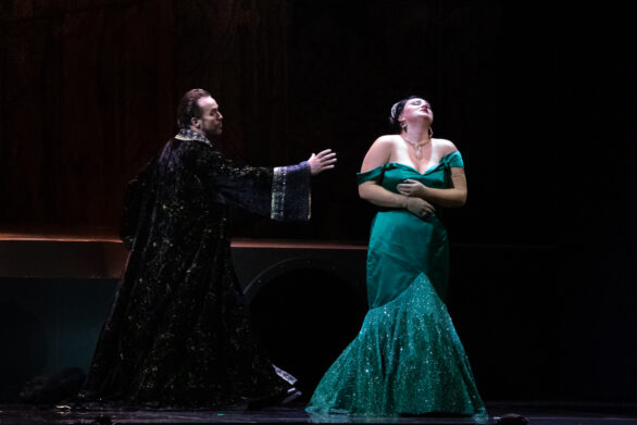 Una donna con un vestito lungo verde e un uomo con un mantello nero stanno interpretando "Turandot"